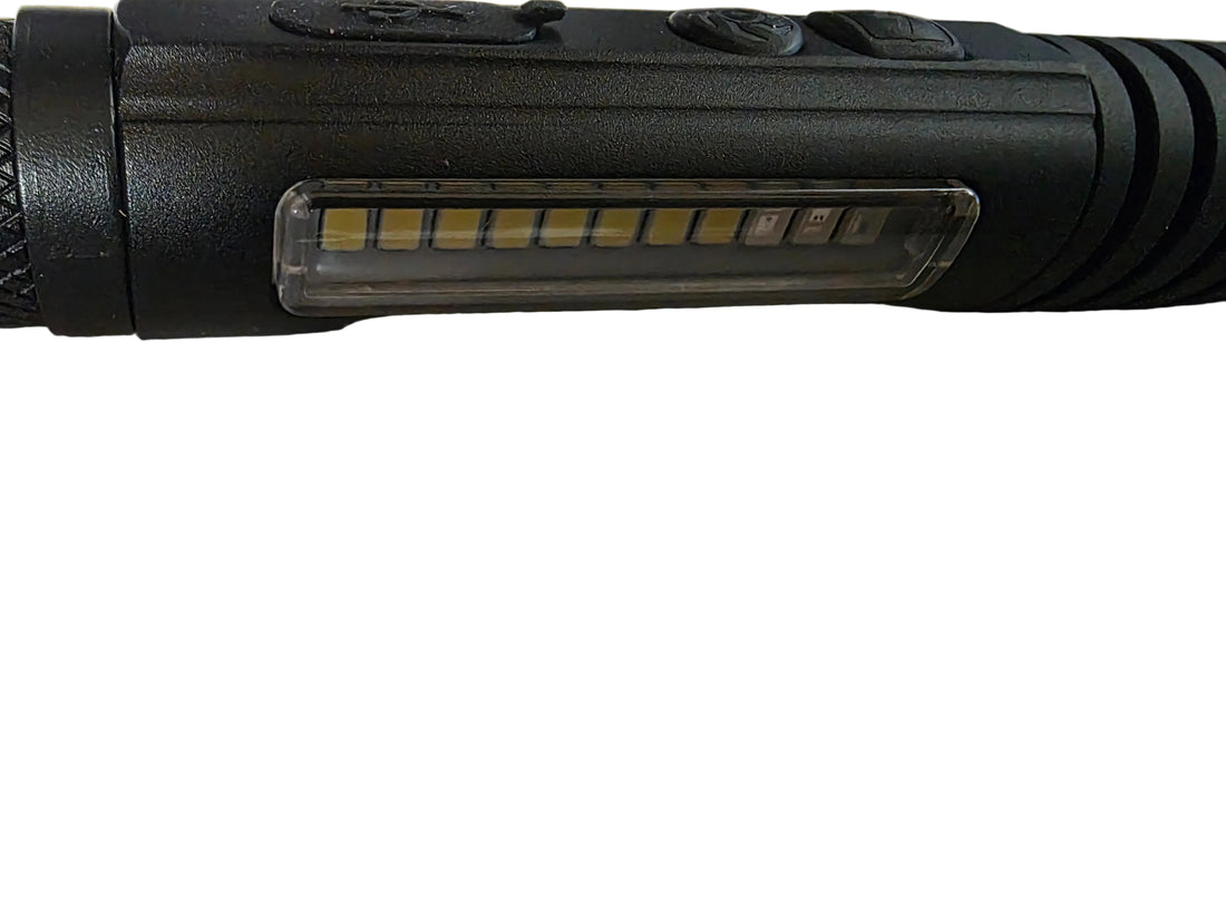 A black tactical LED flashlight with a textured grip and clip, shown alongside a black USB charging cable and a small clear plastic bag containing a red O-ring, all laid out on a white surface.