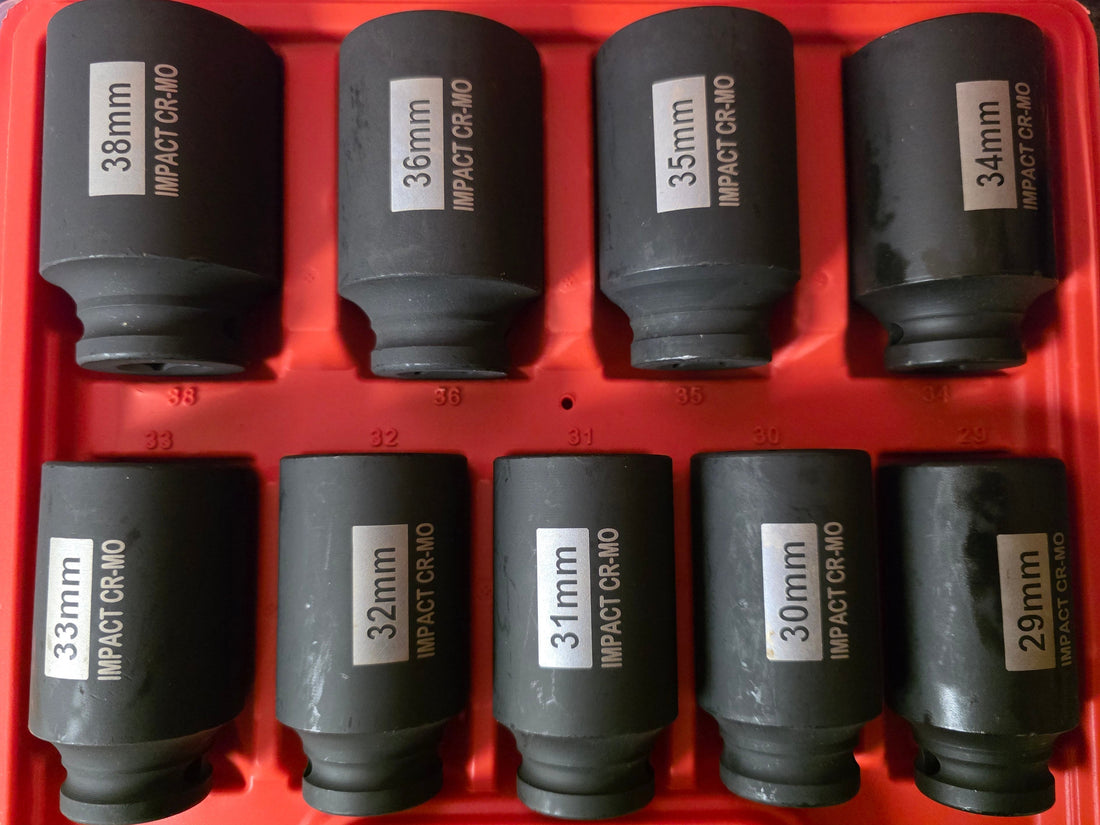 A set of eight black impact socket wrenches in different sizes (29mm to 38mm) arranged in a red plastic case. Each socket has a white label with black text reading '30mm' or its size and 'IMPACT CR-MO'.