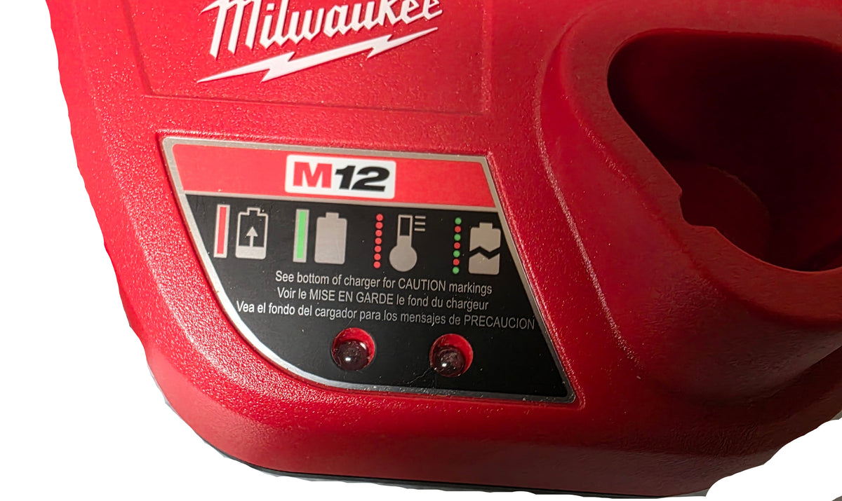 Close-up of a red Milwaukee M12 cordless tool battery charger with a black and red front control panel showing battery and light icons.