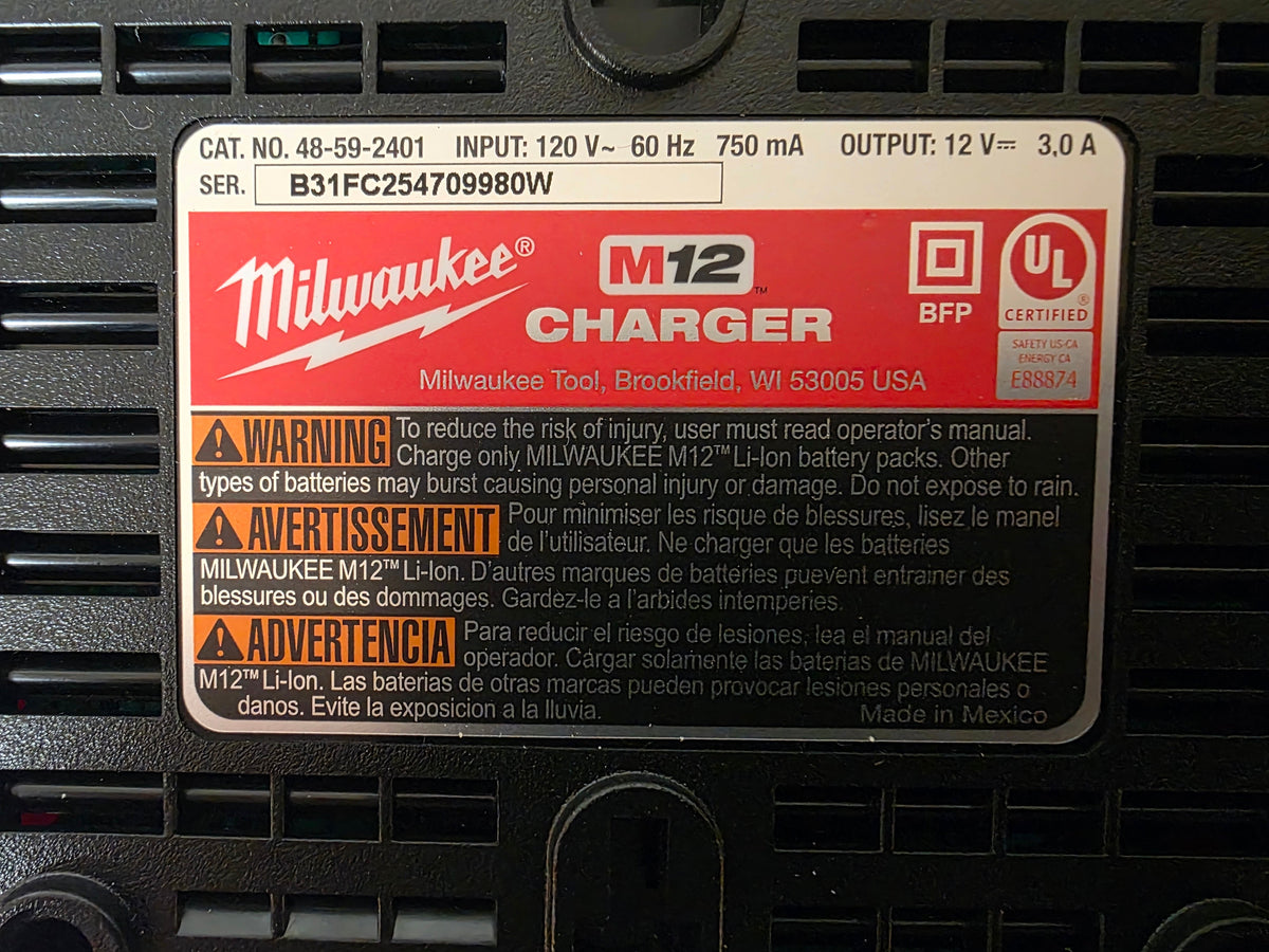 A Milwaukee M12 Charger battery management system label sticker on a black electronic device, showing product specifications and safety warnings.