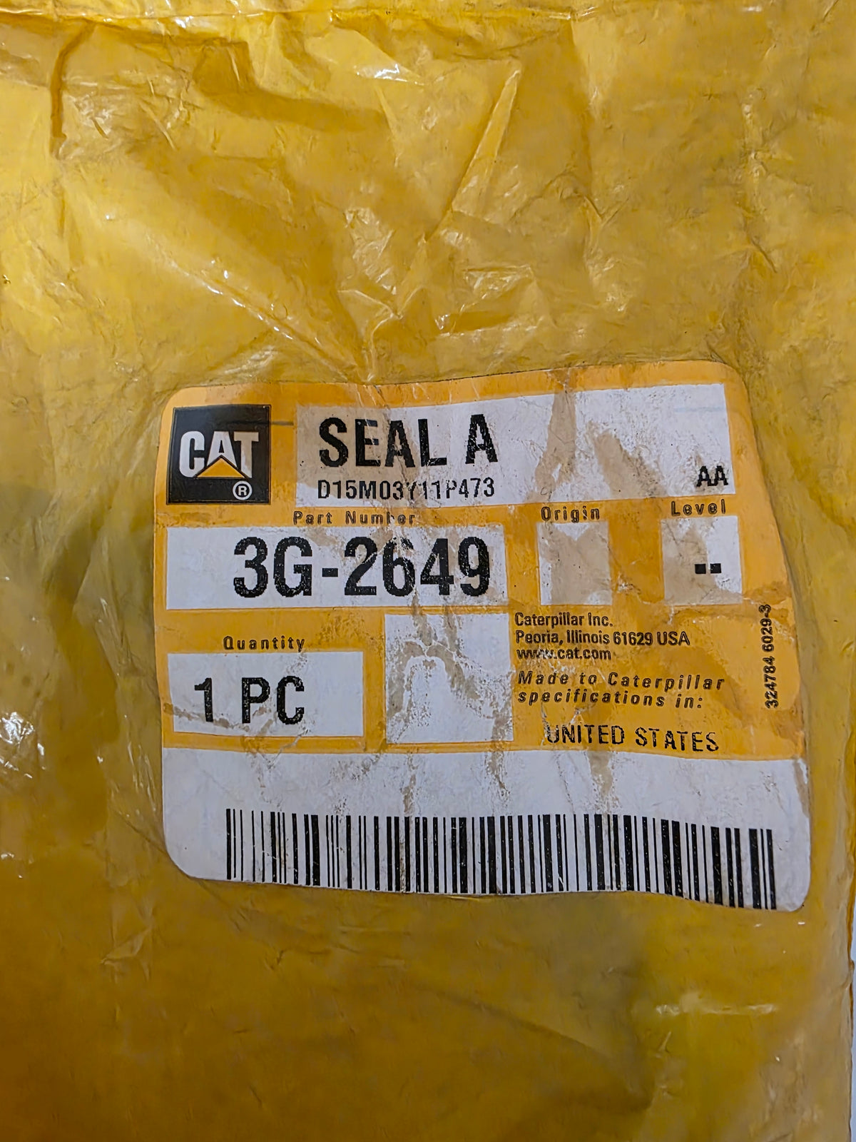 A yellow Caterpillar industrial seal sealed in clear plastic packaging with a white and yellow CAT part label reading SEAL A and part number 3G-2649.
