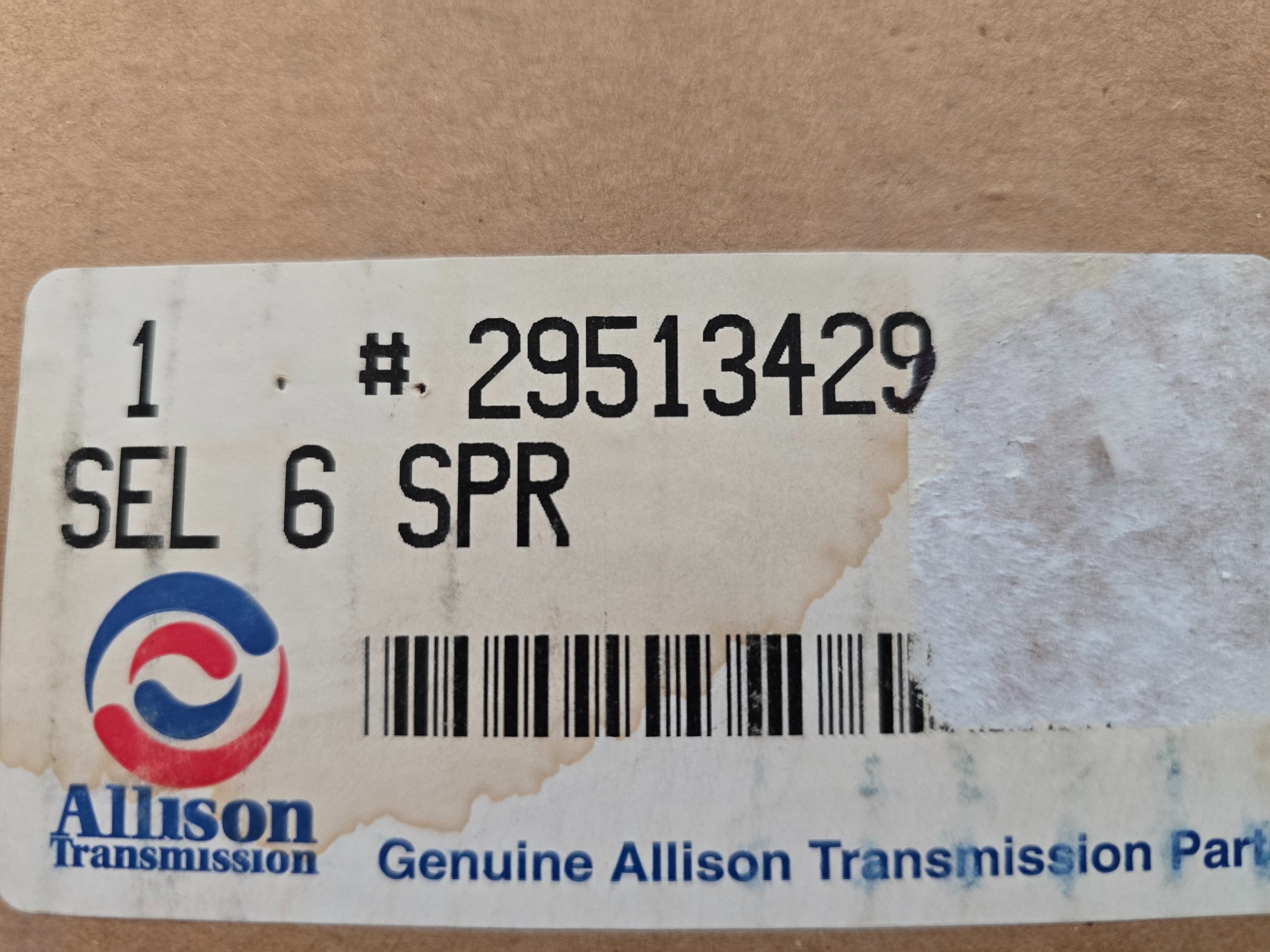 Allison Transmission part label with part number and branding on a cardboard background