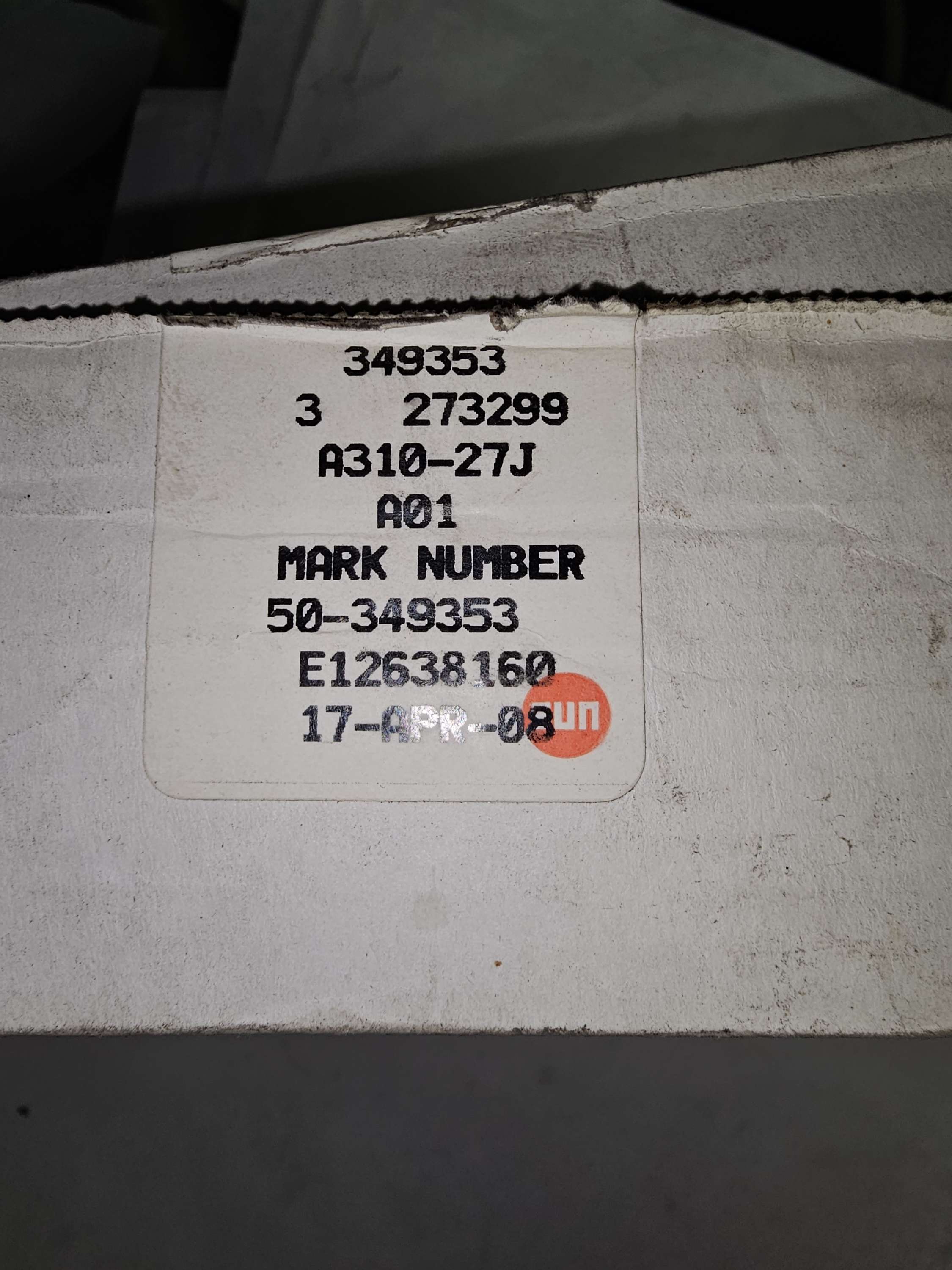 Label with text and a logo on a cardboard surface