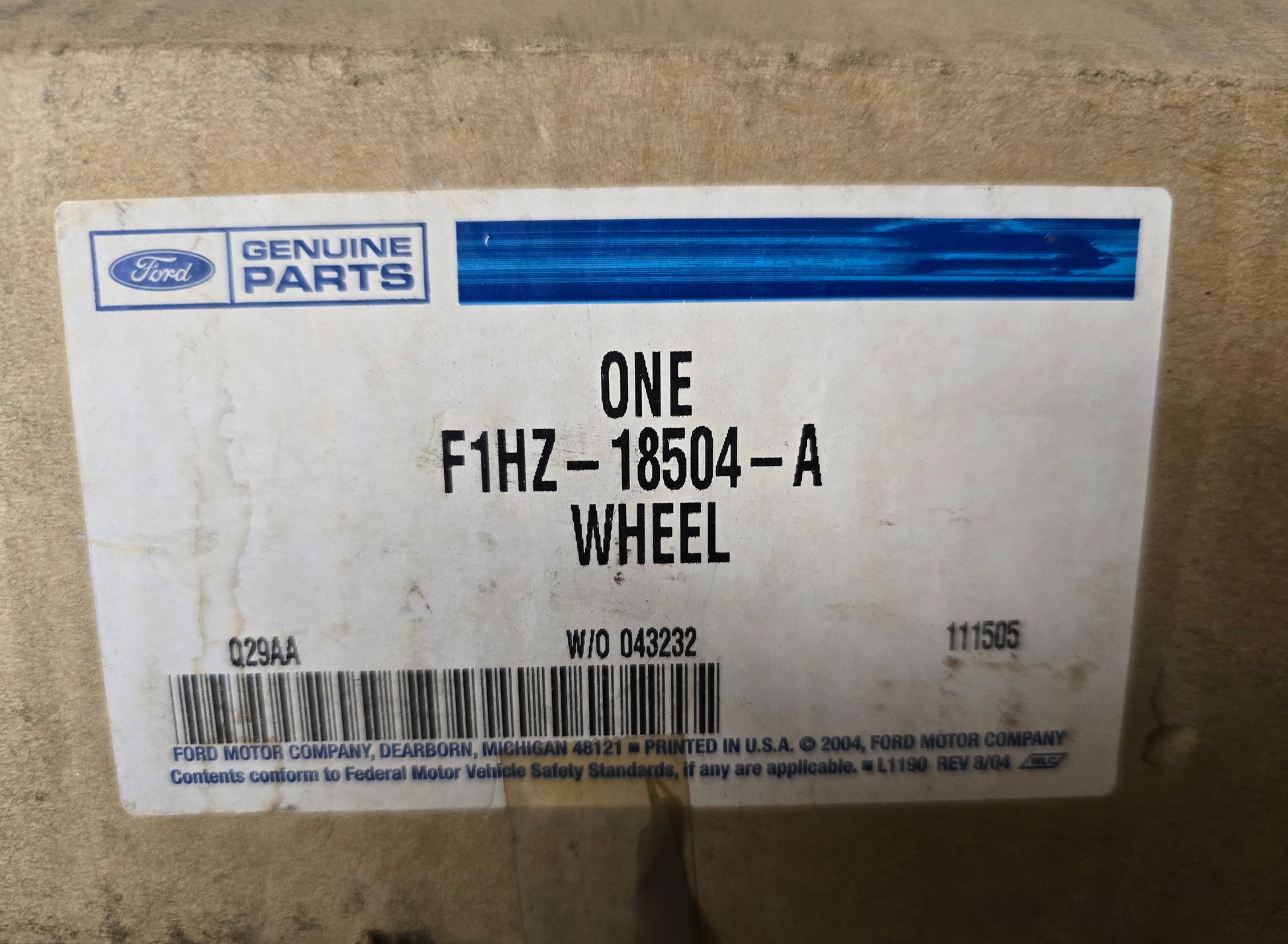 Cardboard box with a Ford Genuine Parts label on a wooden surface