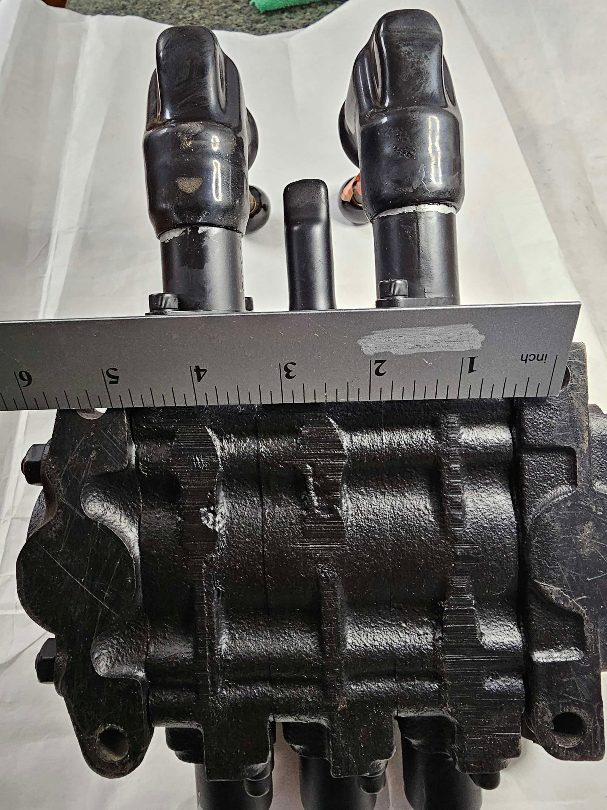 Black mechanical component with measurement tool on a white background