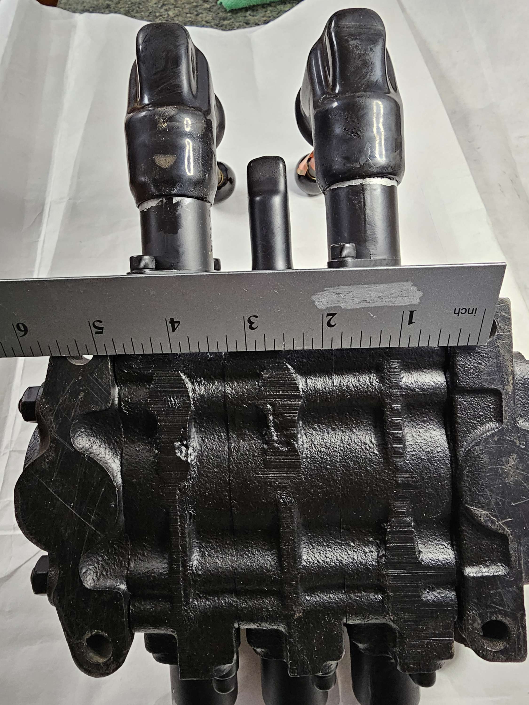 Black mechanical component with measurement tool on a white background